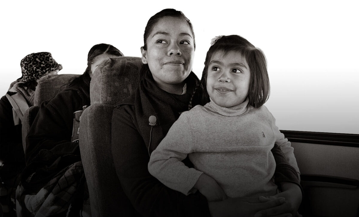 Mother sitting with daughter on bus