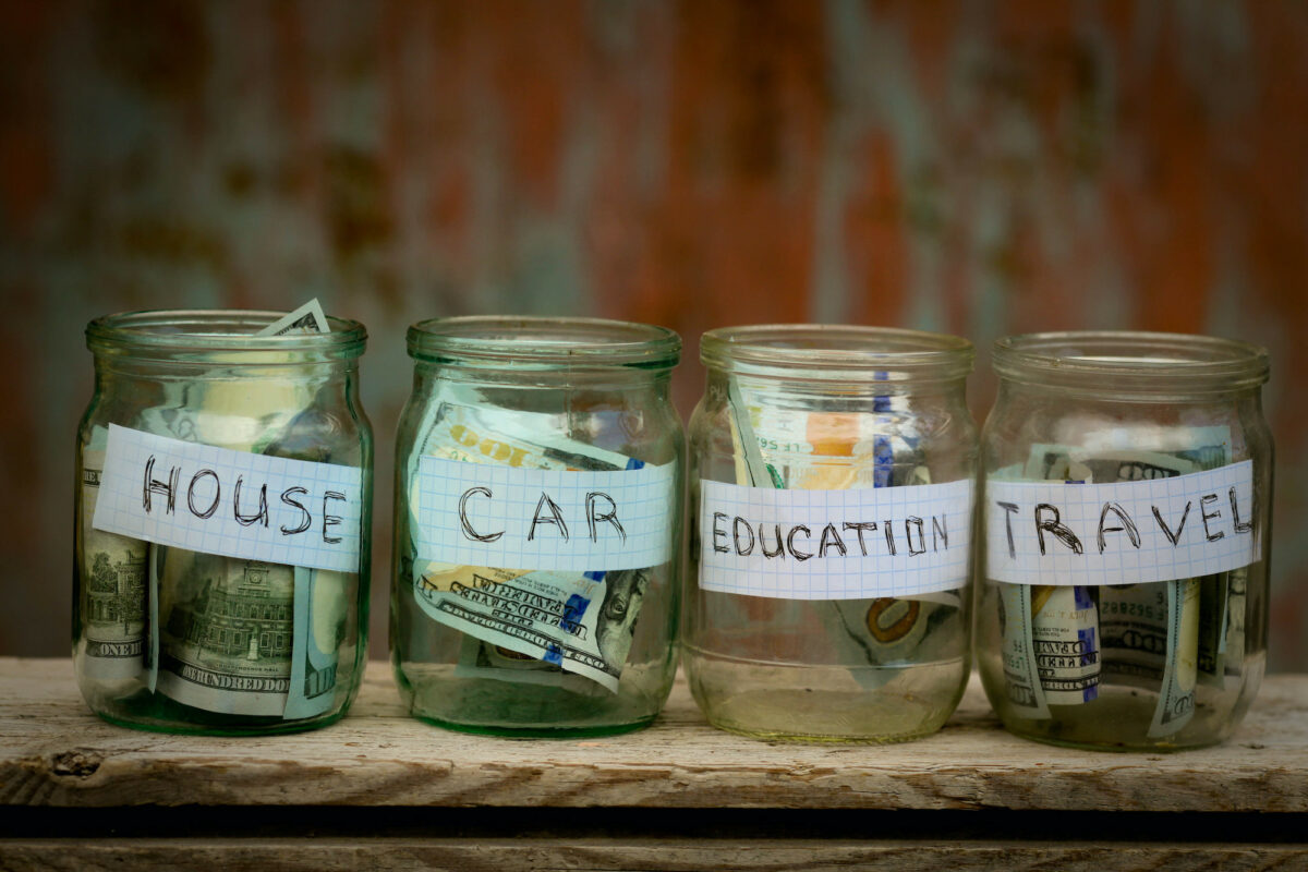 Glass jars with dollars and text: house,car, travel, education